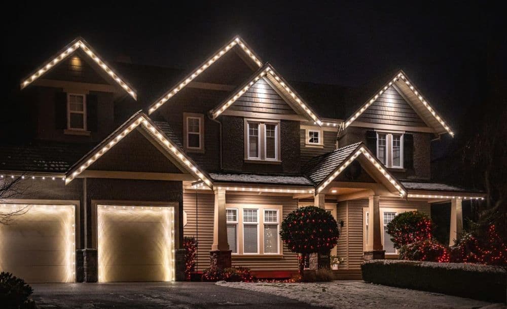 Elegant home decorated with festive Christmas lights at night, showcasing a welcoming atmosphere.
